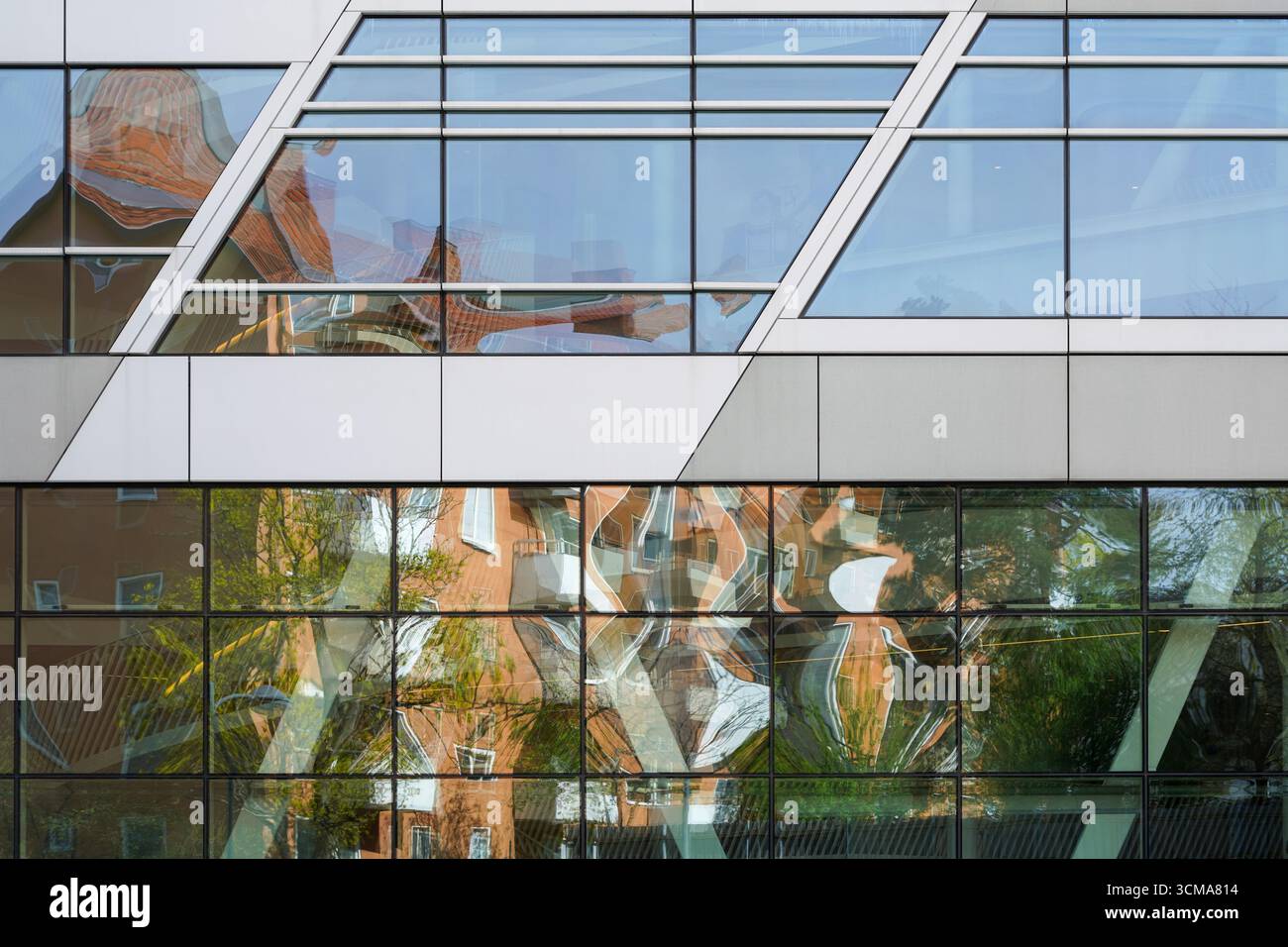 Sinfonie riflettenti: Melodie urbane questa immagine cattura i riflessi dell'ambiente circostante nelle finestre di vetro della sede centrale di Swedbank a Stoccolma, progettata da 3XN Architects. L'interazione dinamica di luce e riflessi trasforma la facciata in una tela di scene urbane distorte ma armoniose. Le linee angolari dell'architettura dell'edificio si accostano alle forme organiche riflesse nel vetro, creando un arazzo visivamente accattivante e in continuo cambiamento. Foto Stock