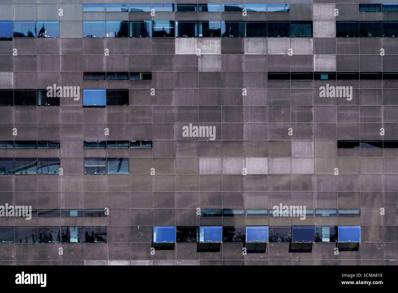 Eleganza monolitica: Il diamante nero di Copenaghen. L'estensione della Biblioteca reale danese a Copenaghen, Danimarca, progettata da Schmidt Hammer & Lassen, presenta una facciata in granito nero proveniente dallo Zimbabwe, con una rigorosa griglia di finestre che riflettono il cielo e l'ambiente urbano circostante. Foto Stock