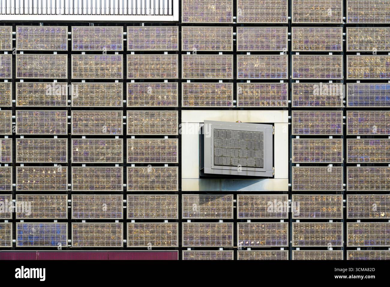 Griglie architettoniche: La facciata in vetro dell'innovazione. La facciata di un garage a Eindhoven, Paesi Bassi, presenta una griglia di pannelli di vetro che riflettono la luce e l'ambiente circostante, trasformando una struttura funzionale in una dichiarazione architettonica dinamica. Foto Stock