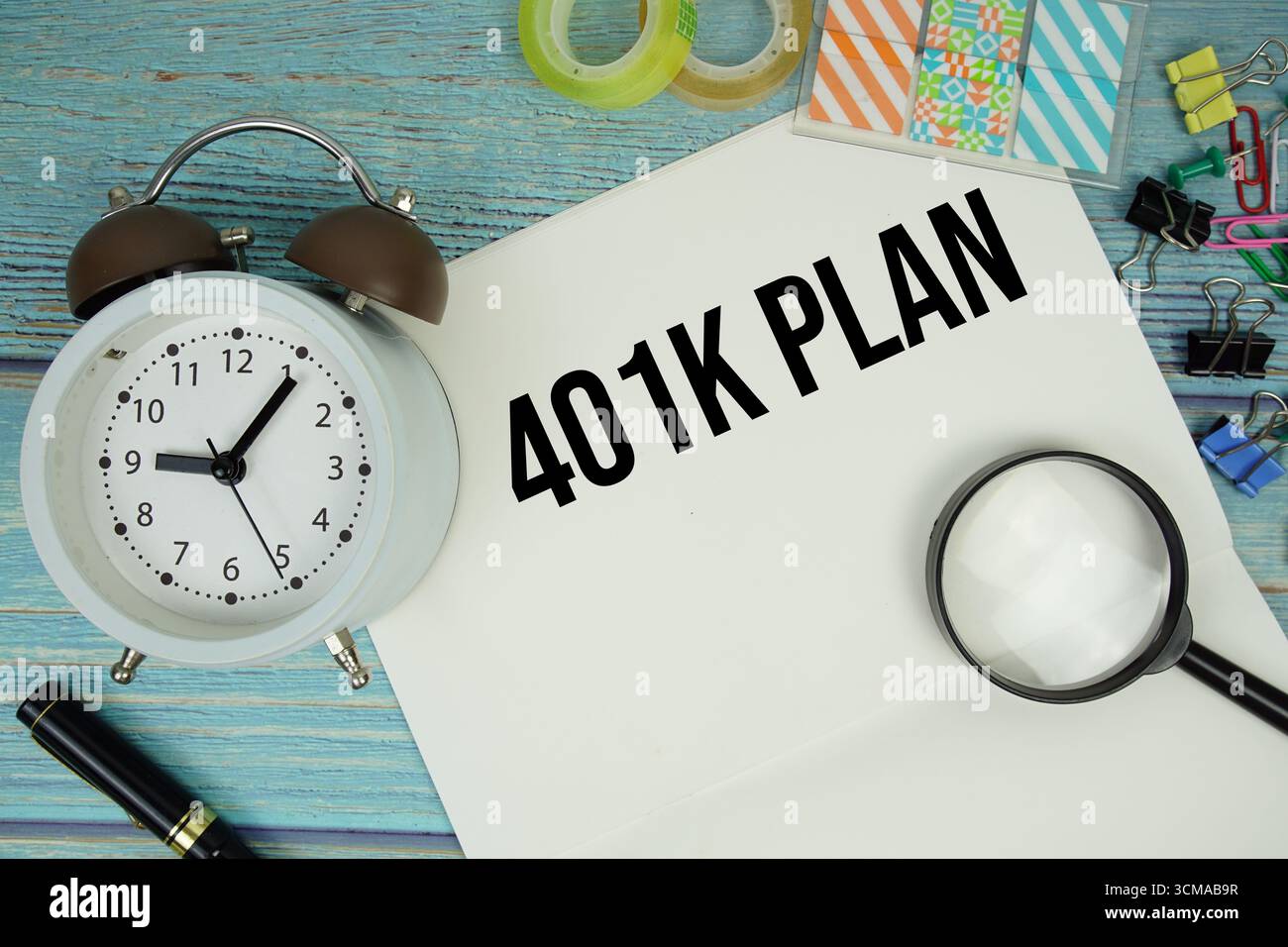 401K testo del piano scritto su blocco note con sveglia e lente di ingrandimento su fondo in legno Foto Stock
