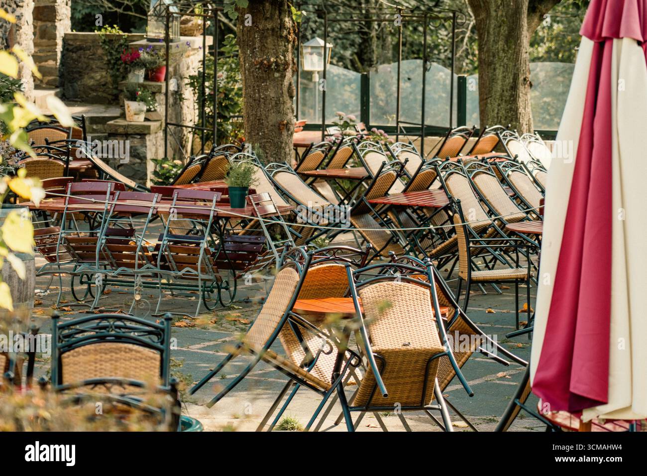 La terrazza del ristorante è chiusa e le sedie sono vuote. Area pranzo all'aperto con sedie ribaltate che simboleggiano il crollo economico della chiusura degli affari Foto Stock