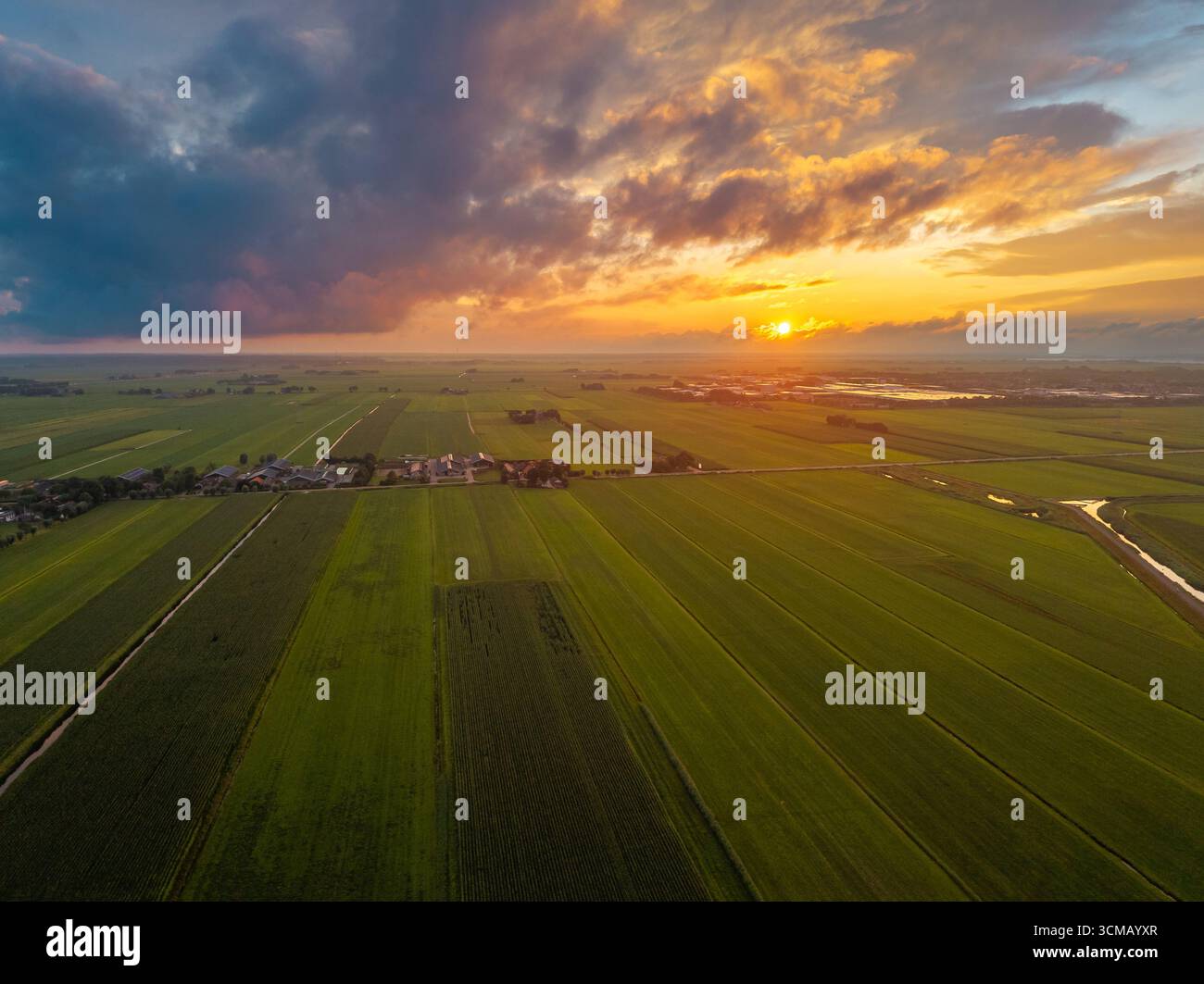 Tranquillo paesaggio olandese con ampi campi e un cielo luminoso all'ora d'oro. Foto Stock