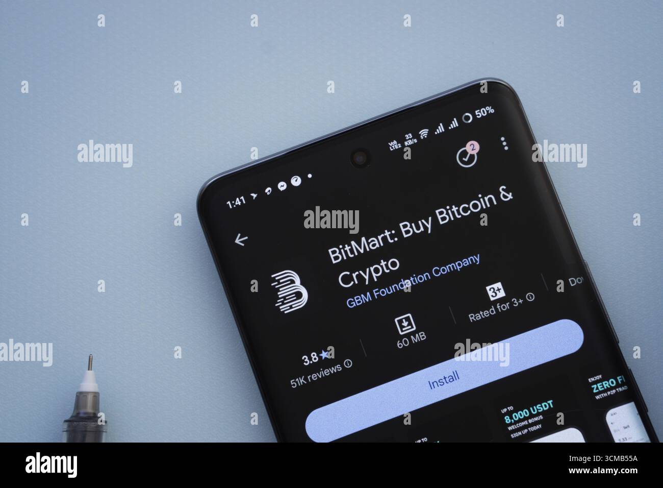 Dacca, Bangladesh - 29 maggio 2025: Su una superficie blu, uno smartphone visualizza l'app BitMart all'interno del Google Play Store Foto Stock