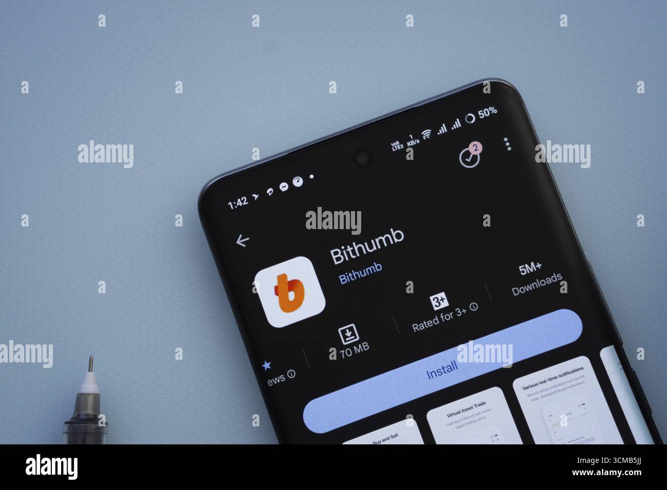 Dacca, Bangladesh - 7 maggio 2025: Su una superficie blu, uno smartphone visualizza l'app Bithumb all'interno del Google Play Store Foto Stock