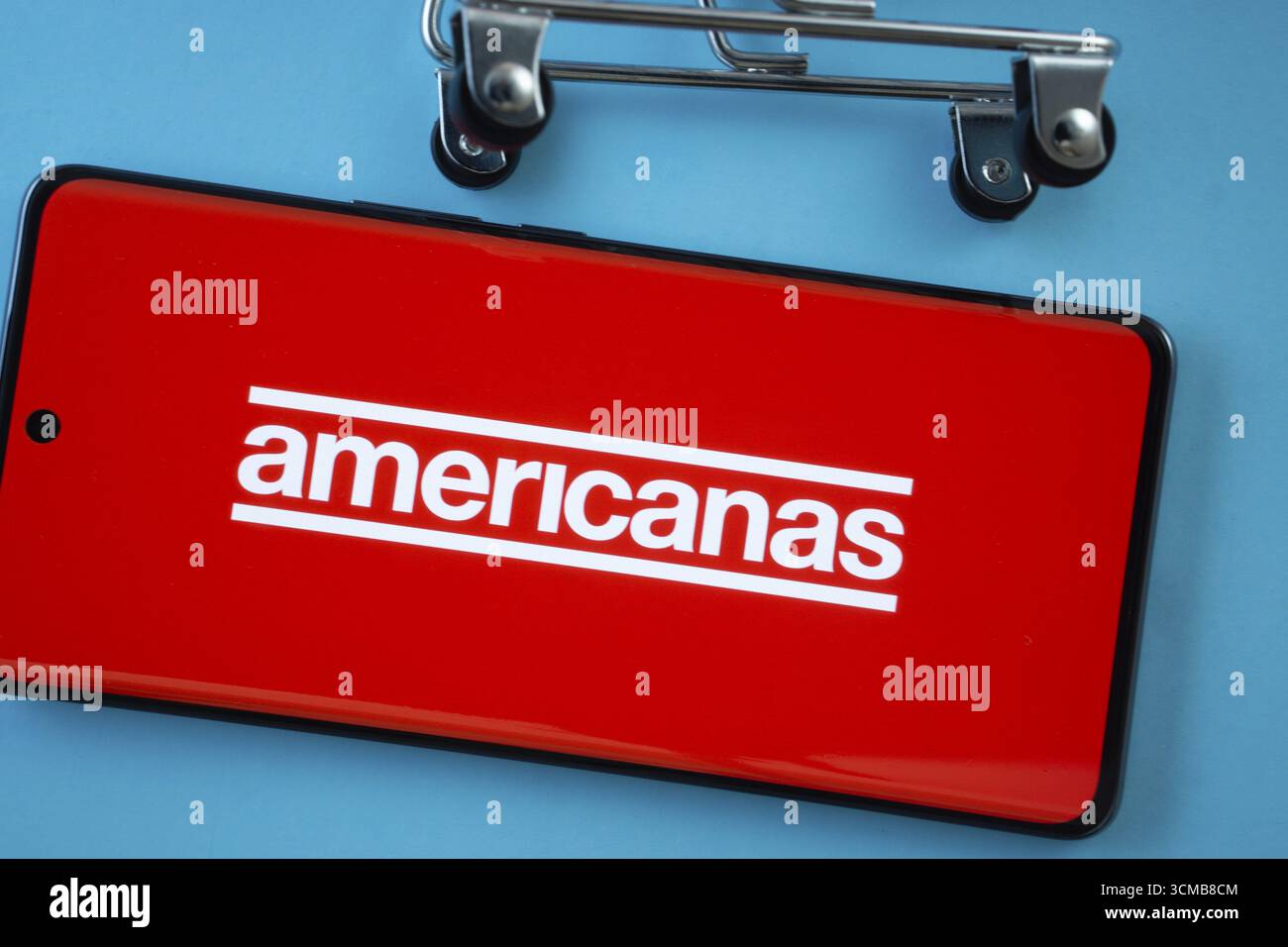 Dhaka, Bangladesh - 3 luglio 2025: Schermo dello smartphone che mostra il logo Americanas con ruote del carrello su sfondo blu Foto Stock