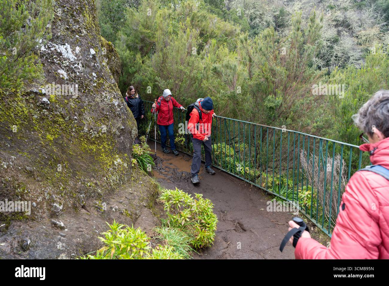 Madeira, Portogallo - 03.22.2025: Turisti che attraversano il fango al punto panoramico Miradouro dos Balcões a Ribeiro Frio, Madeira Foto Stock