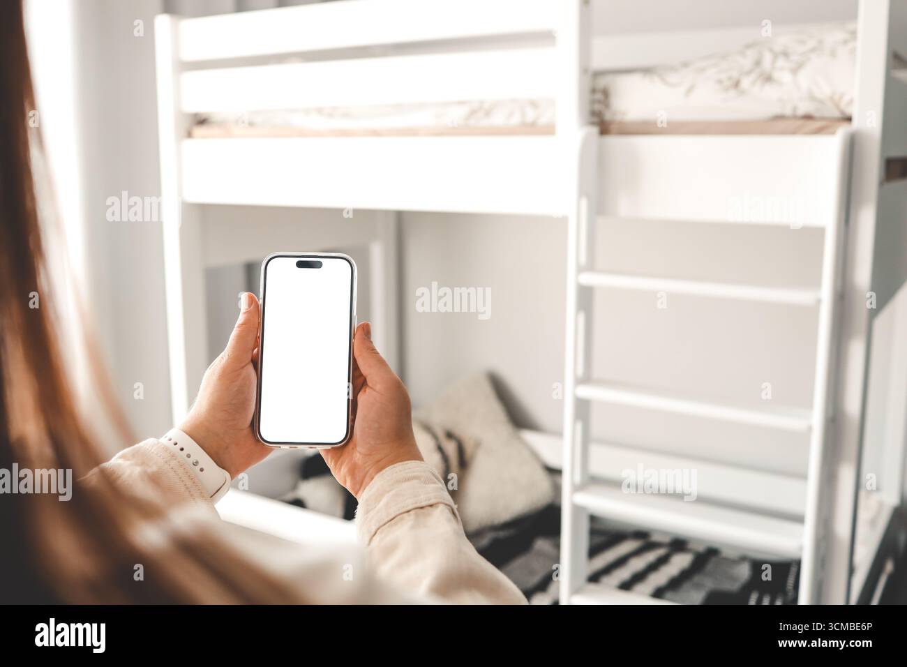 Telefono con schermo isolato nella stanza dei bambini sullo sfondo di un letto a castello, ordinare mobili. Foto Stock
