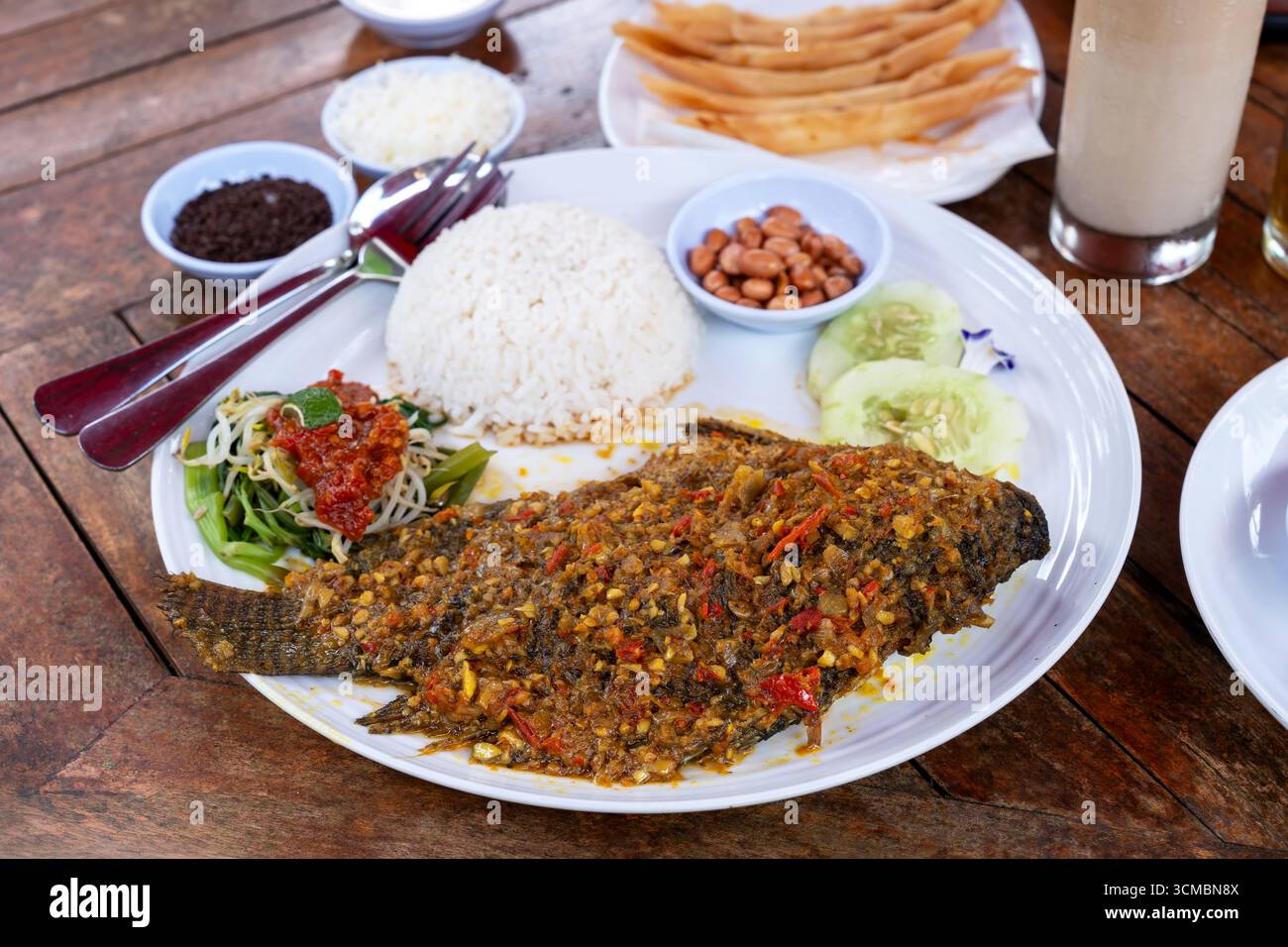 Mujair nyat nyat tilapia fritta piccante con riso e contorni cibo balinese Foto Stock