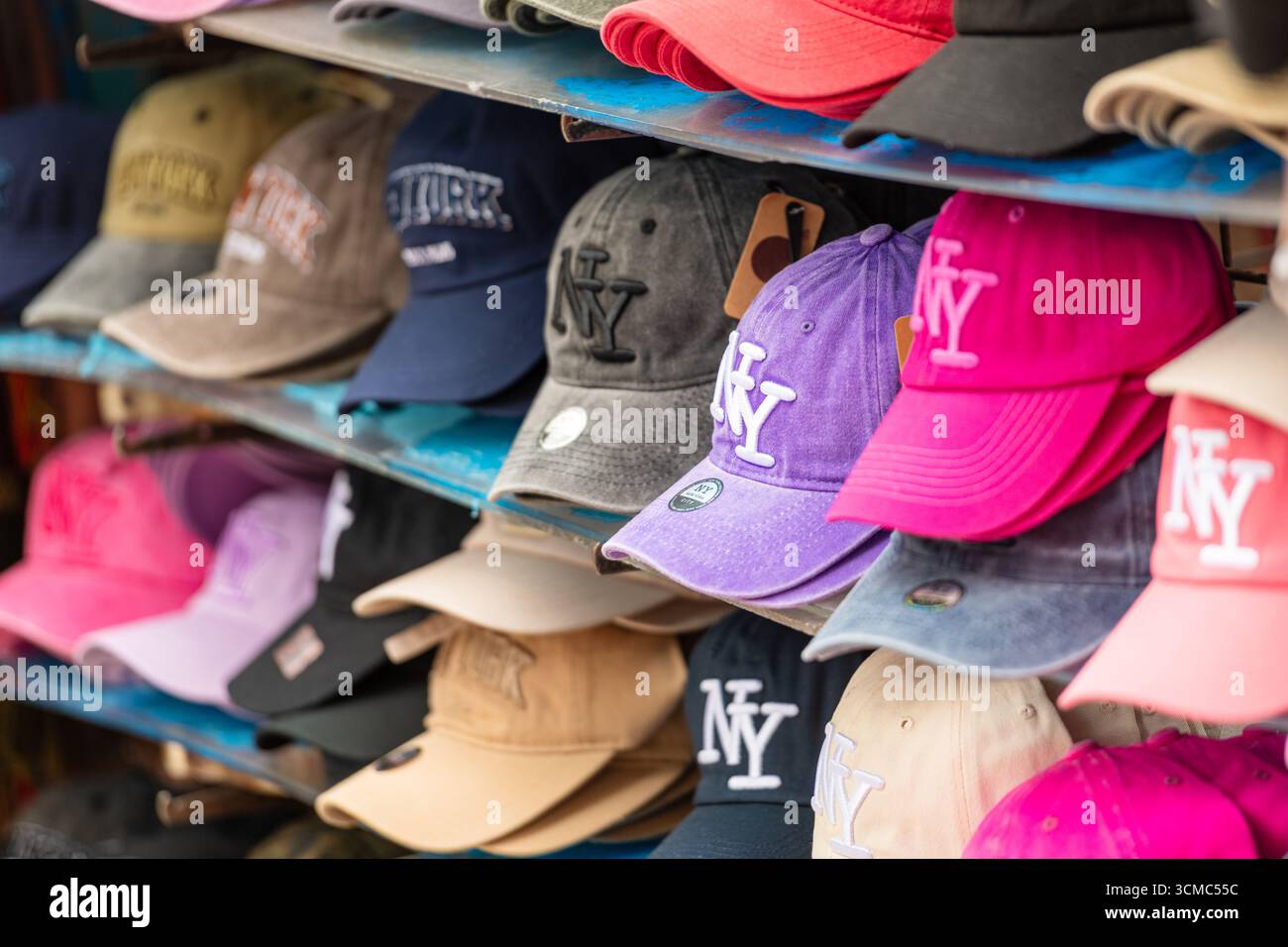 NEW YORK CITY - 25 maggio 2024: Vista ravvicinata di una colorata esposizione di cappelli da baseball di New York disposti sugli scaffali di un negozio di strada. Il sistema CAPS com Foto Stock