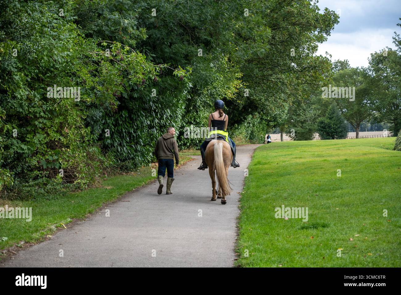 Cavaliere e camminatore su un sentiero alberato presso la tenuta Wentworth Woodhouse, South Yorkshire, una storica residenza di campagna e terreni Foto Stock