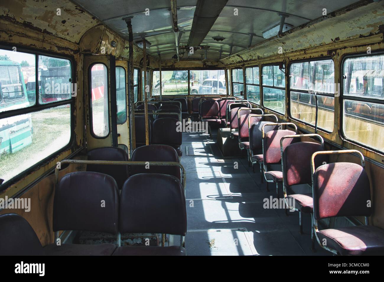 Interno dell'autobus d'epoca abbandonato con posti a sedere vuoti Foto Stock