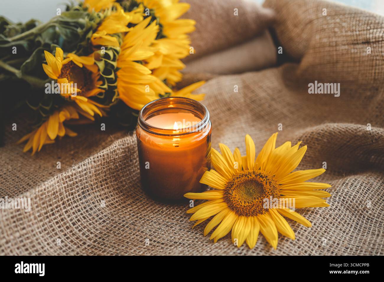 Candele accese e girasoli, estetica rurale. Foto Stock