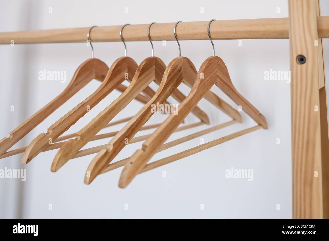 Appendiabiti in legno / appendiabiti su sfondo bianco. Potenziale spazio di copia sopra e all'interno del gancio. Foto Stock