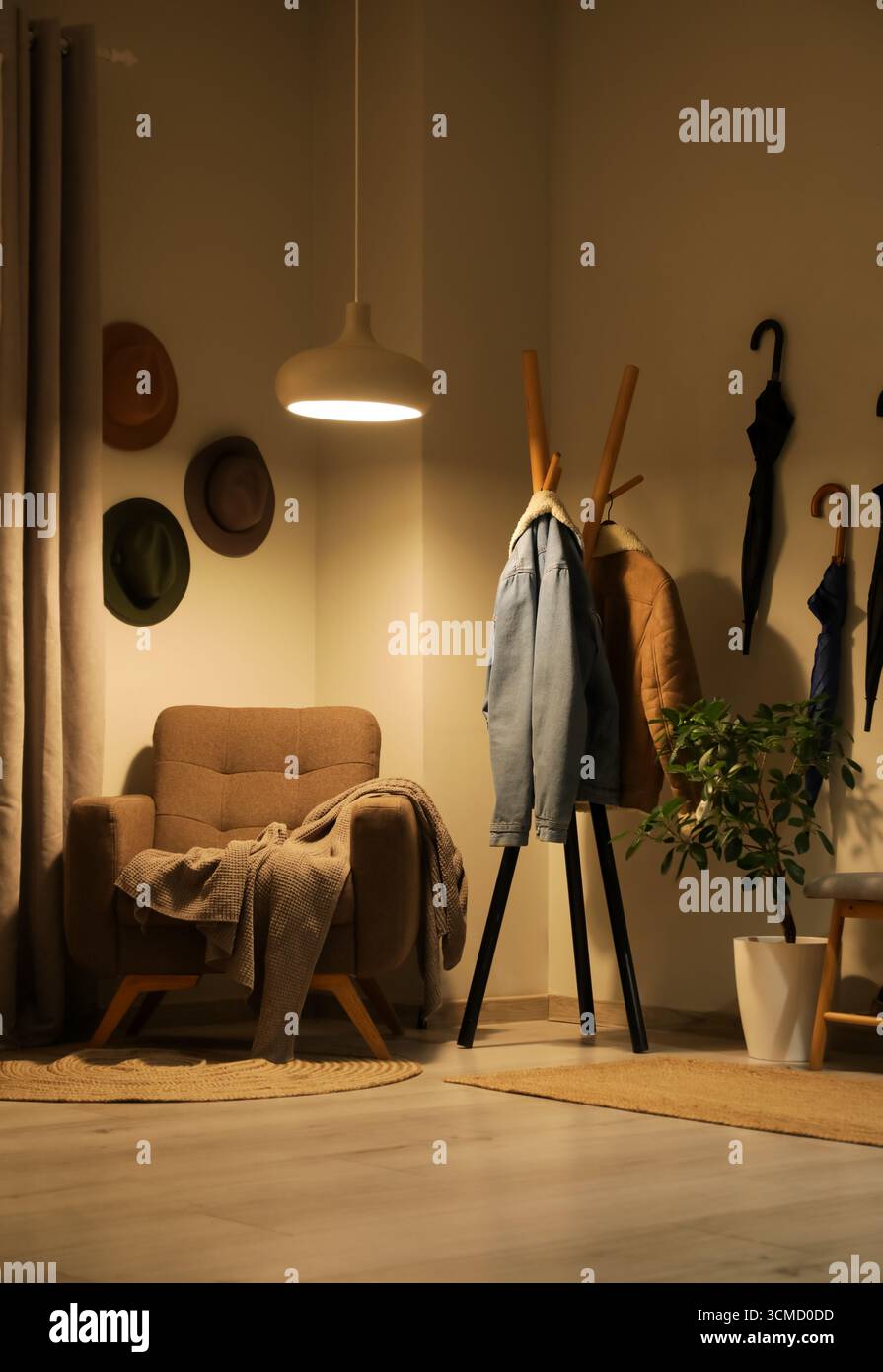 Poltrona, appendiabiti e lampada a incandescenza all'interno del corridoio Foto Stock