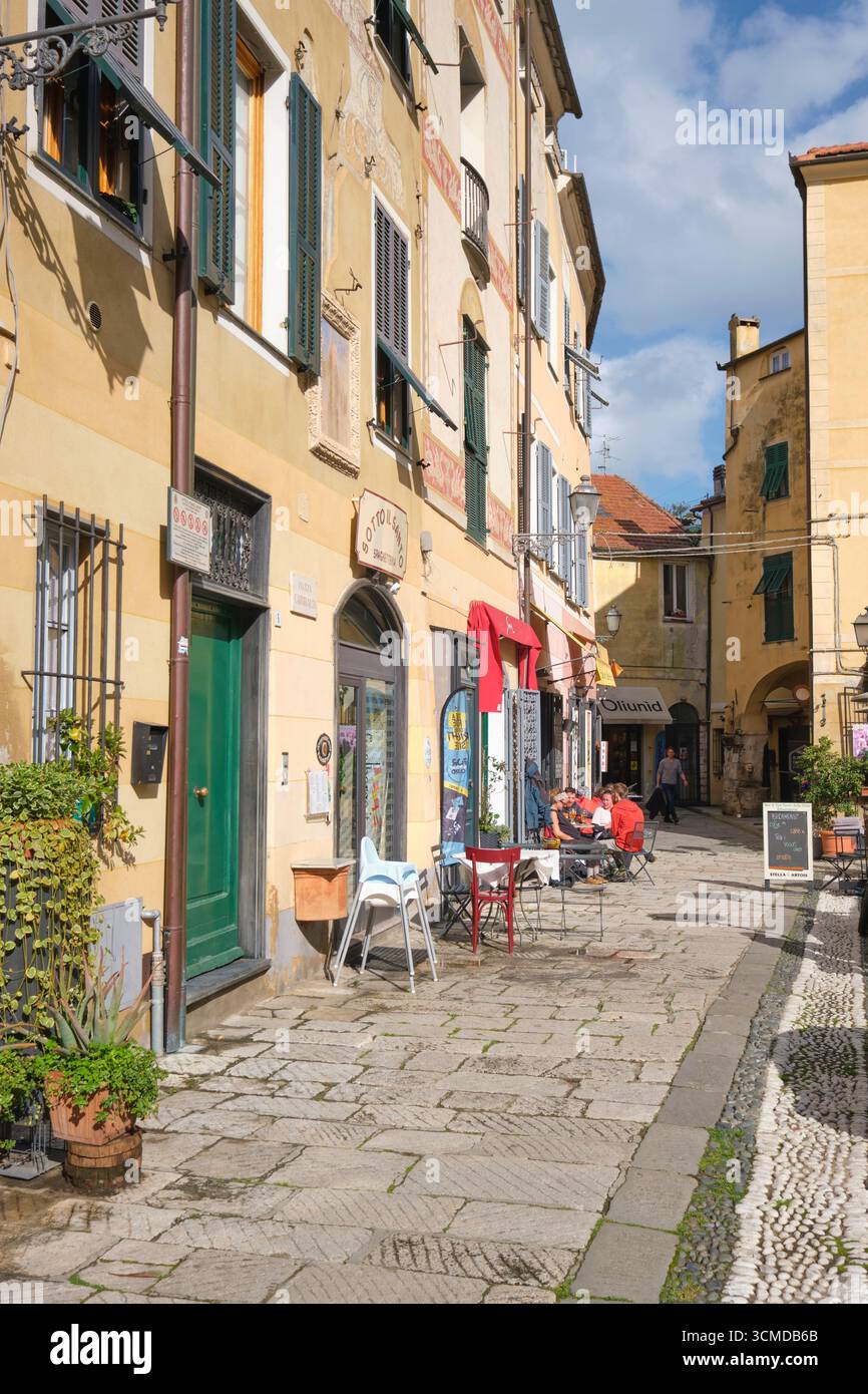 Ristoranti, caffetterie, annidati in stradine, strade, piazze. Nel centro storico di Finalborgo in Liguria, Italia. Foto Stock