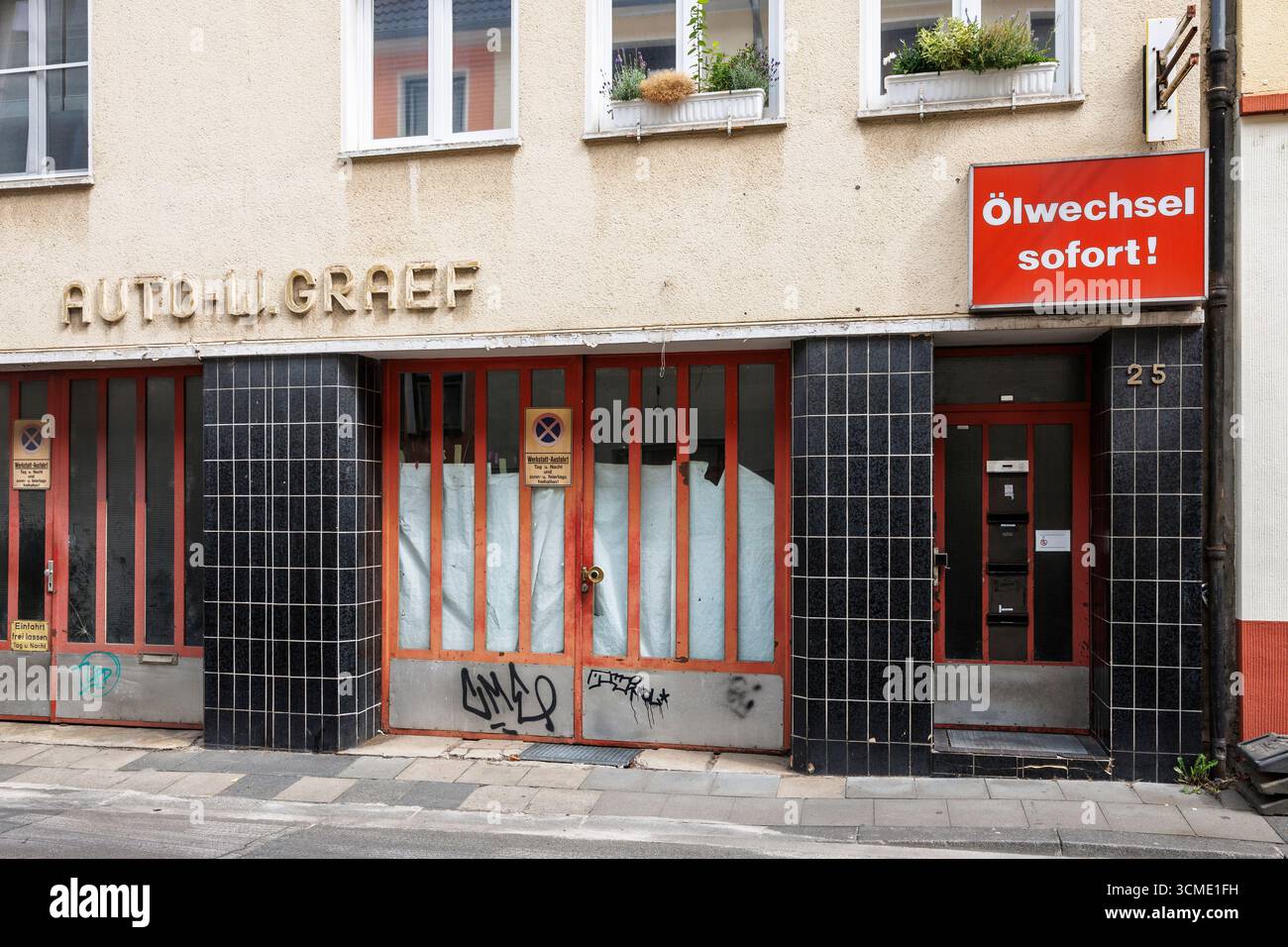 Ingresso piastrellato della casa e negozio di riparazione auto in Graben Street nel quartiere Deutz, Colonia, Germania. Gefliester Hauseingang und Autowerkstatt in der Gra Foto Stock