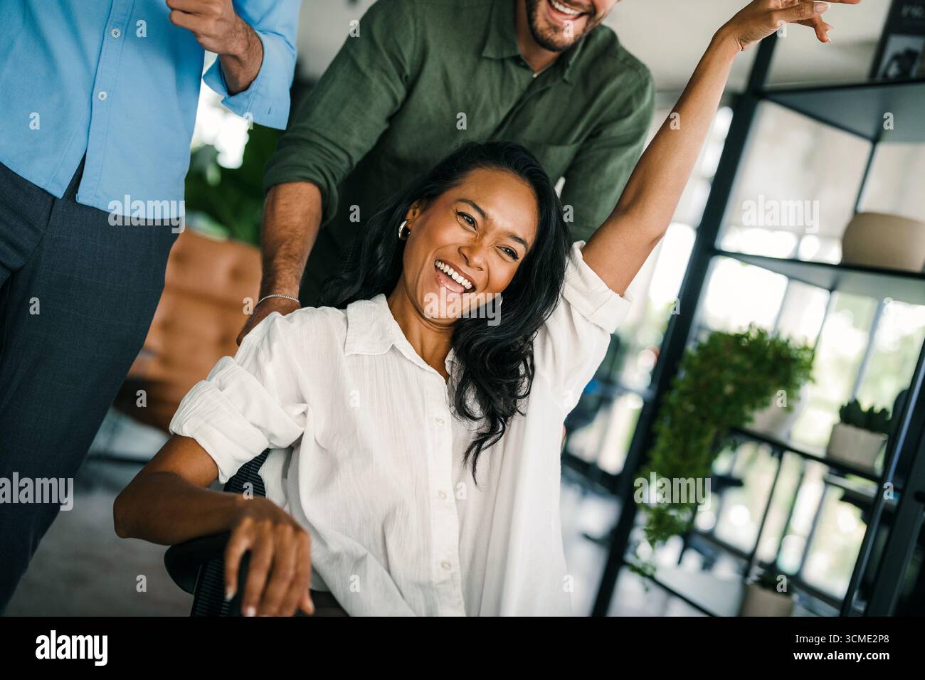 Un gruppo di giovani lavoratori d'ufficio multirazziali e diversificati viene colto in un momento di gioia spontanea. Foto Stock