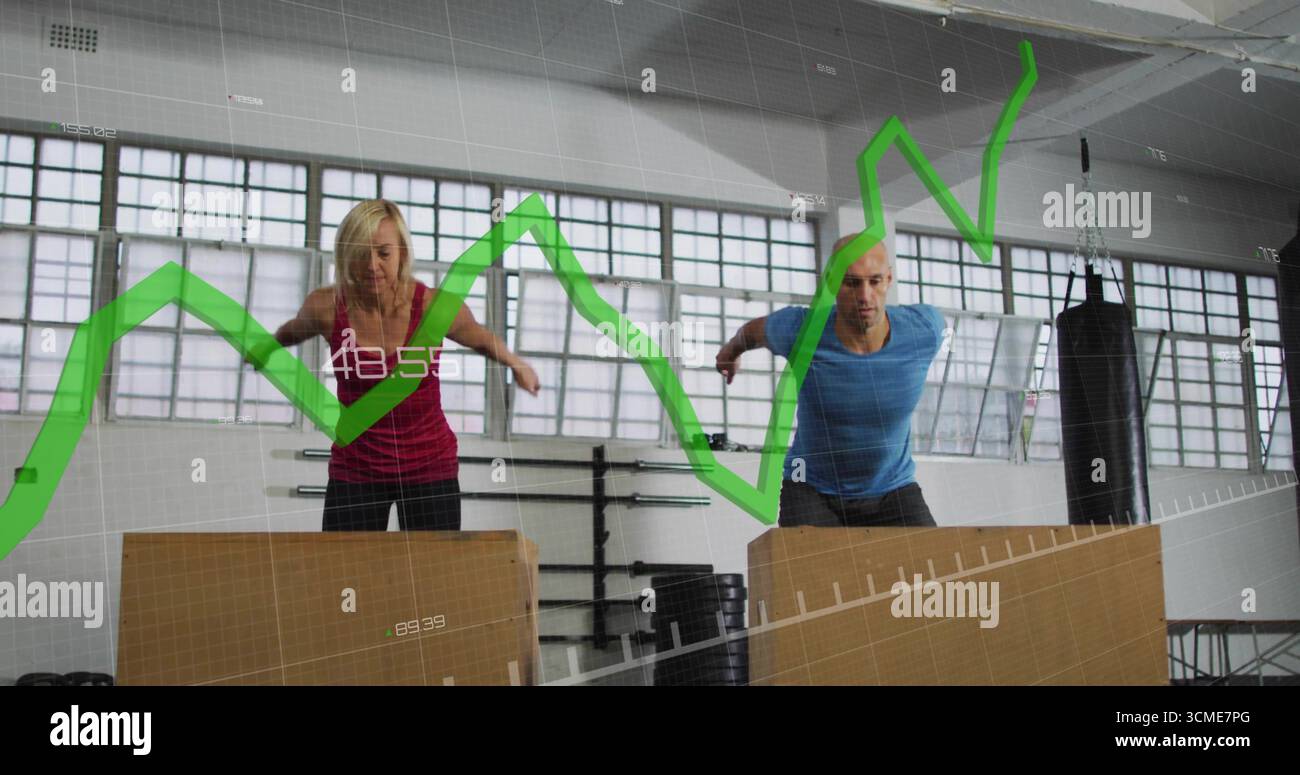 I partner di allenamento eseguono salti in palestra, con caselle plyometriche e sovrapposizione di grafici verdi Foto Stock I partner di allenamento eseguono salti in palestra, con caselle plyometriche e sovrapposizione di grafici verdi Foto Stock