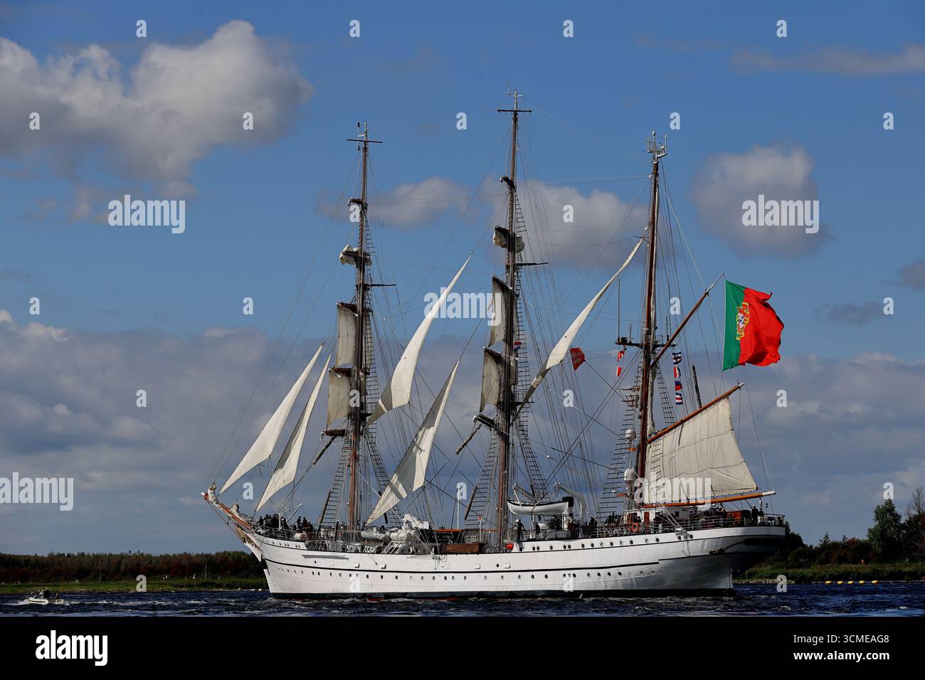Veliero portoghese con vele e bandiera nazionale in partenza da Sail 2025 sul Canale del Mare del Nord vicino ad Amsterdam, Paesi Bassi, vista sul porto. Foto Stock