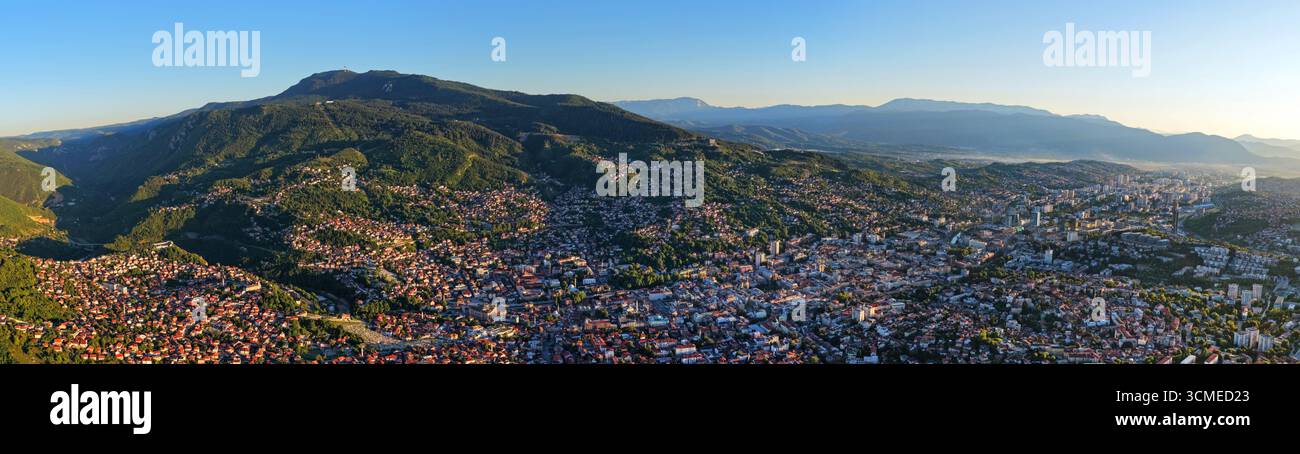 Ampia vista panoramica con drone della città di Sarajevo e del monte Trebevic sotto il cielo azzurro durante l'estate Foto Stock