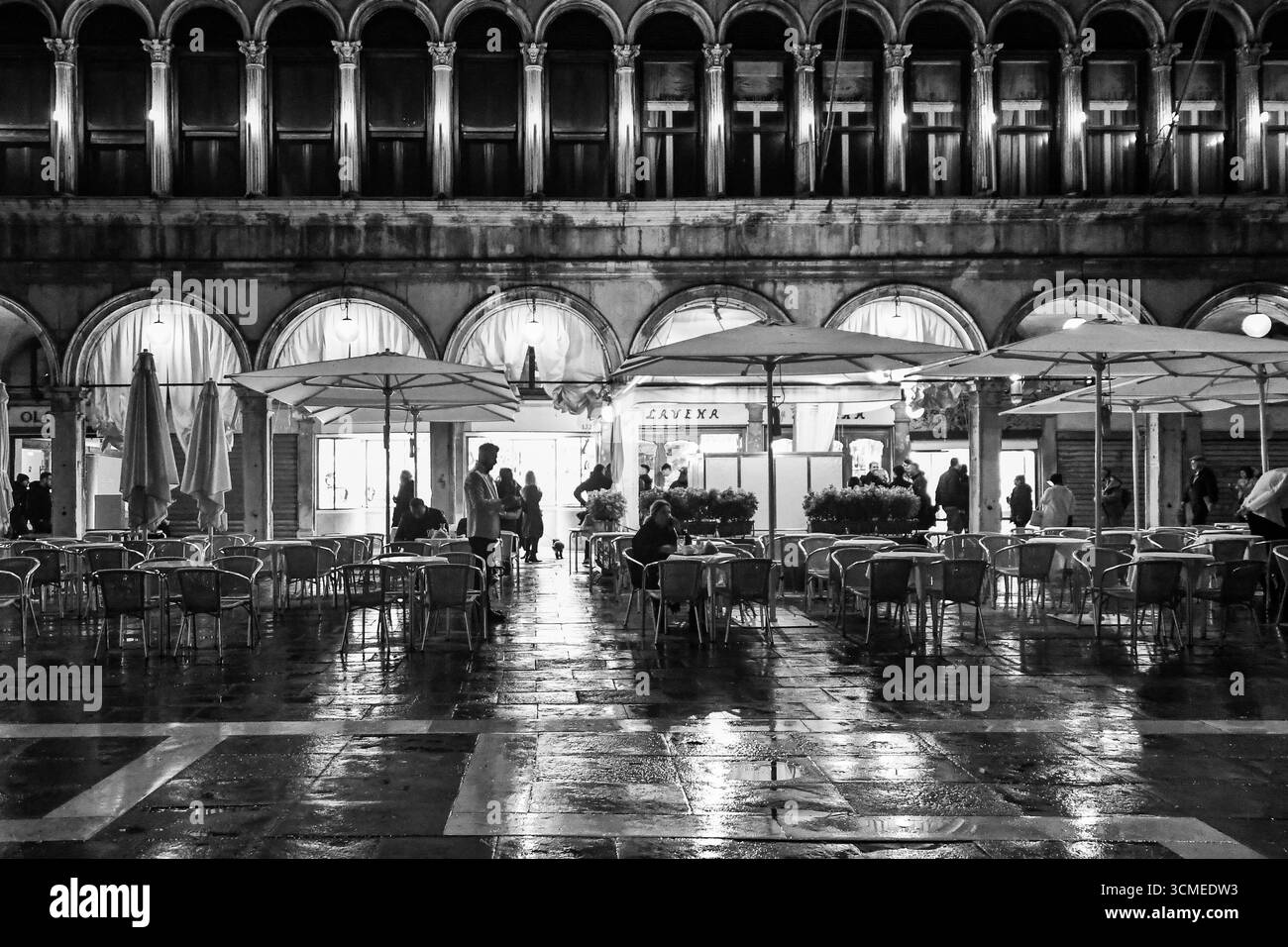 B&W Esterno del caffè Lavena, storica caffetteria fondata nel 1750 nella famosa Piazza San Marco, durante una tempesta di primavera, Venezia, Veneto, Italia Foto Stock