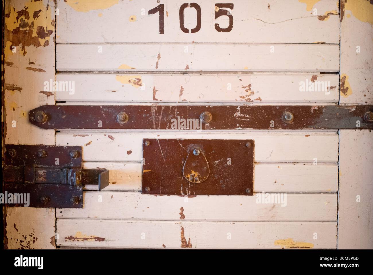 Porta pesante in legno della prigione con serratura di ferro e numero 105 della cella di epoca comunista del Centro europeo di solidarietà di Danzica, in Polonia, relativa a questioni politiche Foto Stock