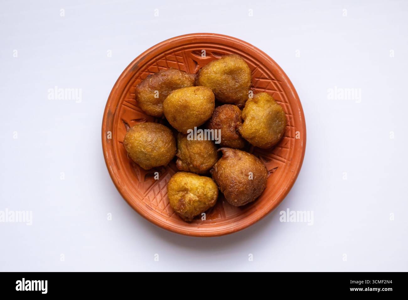 Vista dall'alto della deliziosa, morbida e spugnosa taler pitha (frittelle di palma), un tradizionale spuntino dolce del Bangladesh, servito su un piatto rustico di argilla. Foto Stock