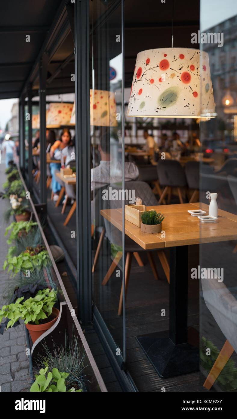 Un tavolo vuoto in un accogliente ristorante attende i clienti. I visitatori trascorrono del tempo ai tavoli sulla terrazza del ristorante terra Foto Stock