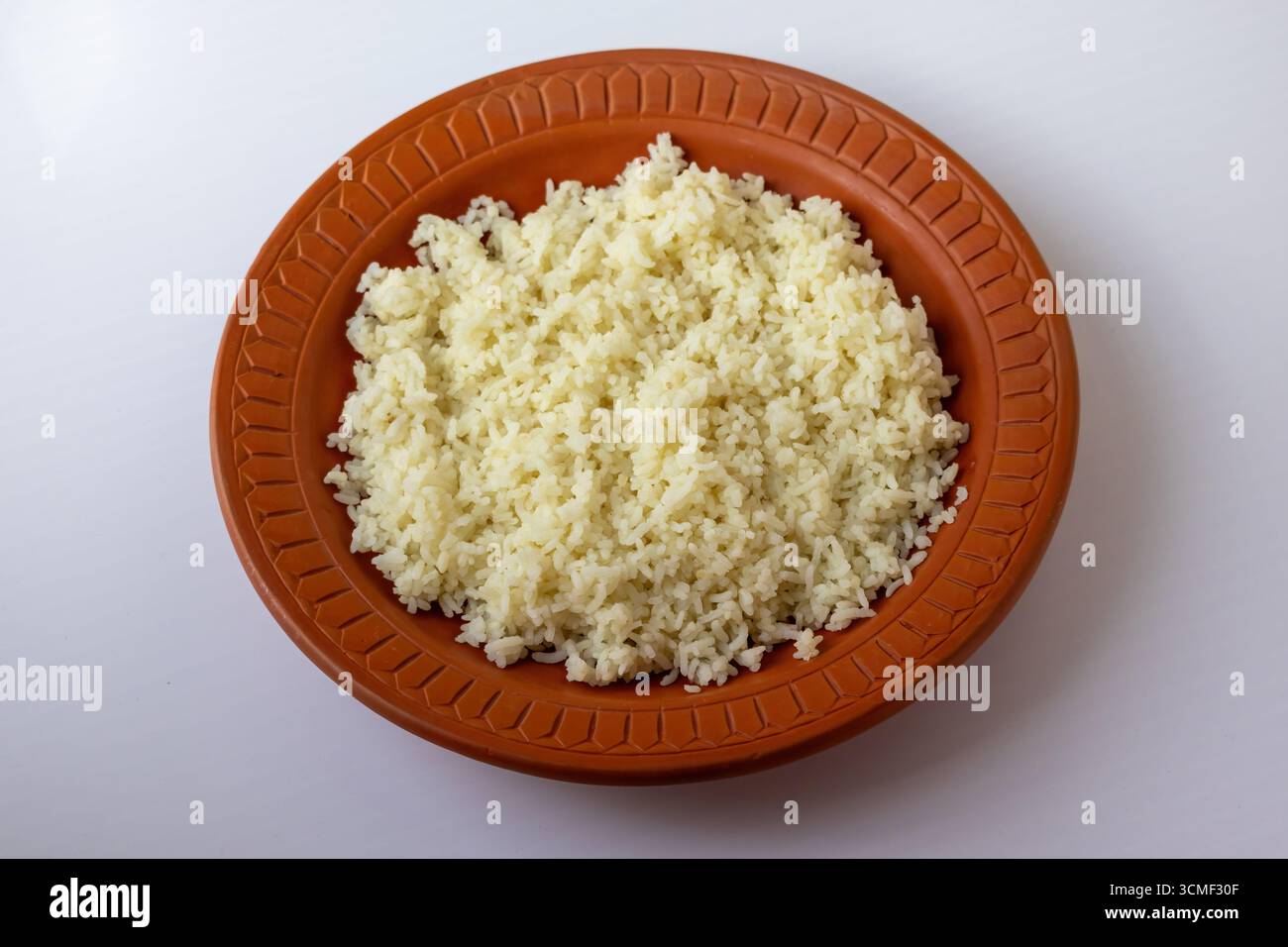 Riso bianco semplice, un cibo tradizionale, servito in una ciotola rustica di argilla. Questo comune piatto del Bangladesh simboleggia il comfort, la semplicità e la cultura Foto Stock