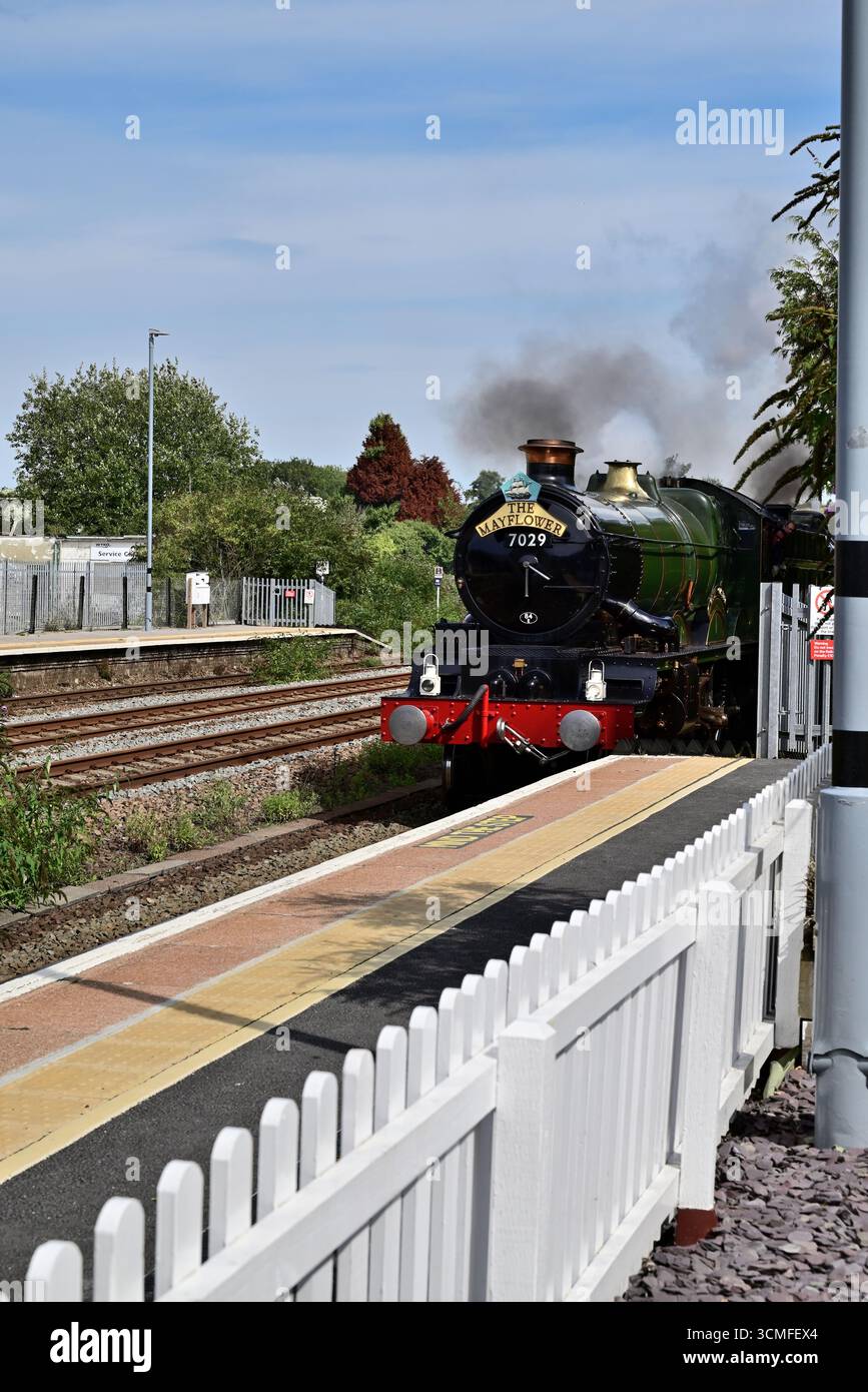 Il castello GWR classe No 7029 Clun Castle si avvicina alla piattaforma della stazione di Totnes con il tour ferroviario Mayflower a Plymouth, pilotando il numero 45596 delle Bahamas. Foto Stock