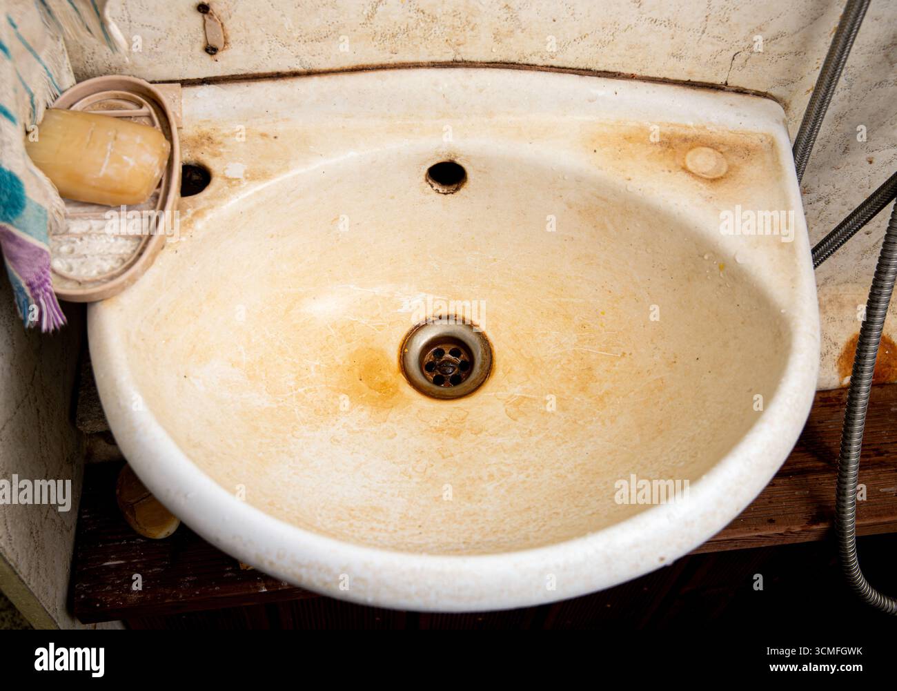 L'acqua ricca di ferro ha danneggiato il lavandino del bagno e ha lasciato un brutto strato arancione di residui. Foto Stock