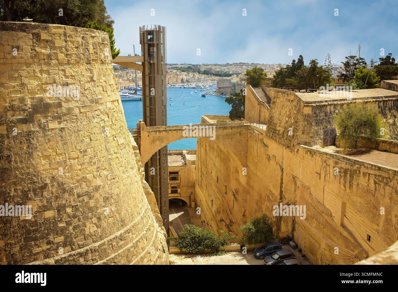 Una vista panoramica delle fortificazioni della Valletta con l'ascensore Barrakka, la strada della città, il Grand Harbour e il paesaggio urbano di Malta. Foto Stock