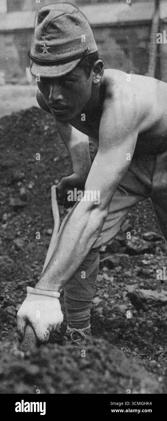 Prigionieri giapponesi al lavoro al porto di Singapore - questo giapponese indossa un guanto bianco per spalmare carbone. Dall'occupazione alleata di Singapore, i soldati giapponesi sono stati messi al lavoro dentro e intorno alla città. Di solito sono sorvegliati da truppe indiane che li mantengono al lavoro e impediscono anche alla popolazione civile di avvicinarsi troppo. 1° ottobre 1945. Foto Stock