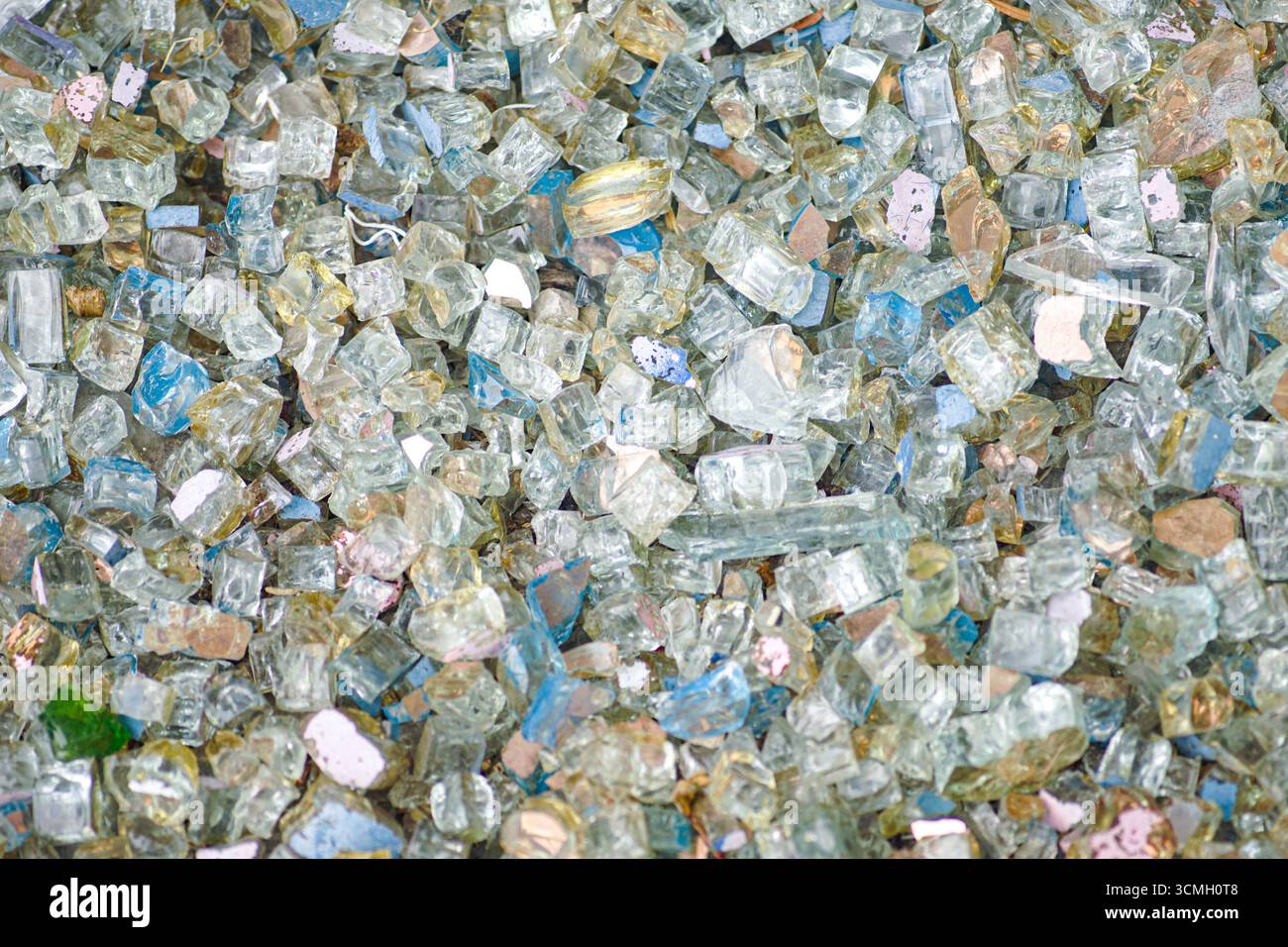 Molti pezzi di vetro rotto di colori diversi. Superfici scintillanti, estetica astratta brillante e motivi vivaci. Concetto di utilizzo del vetro riciclato Foto Stock