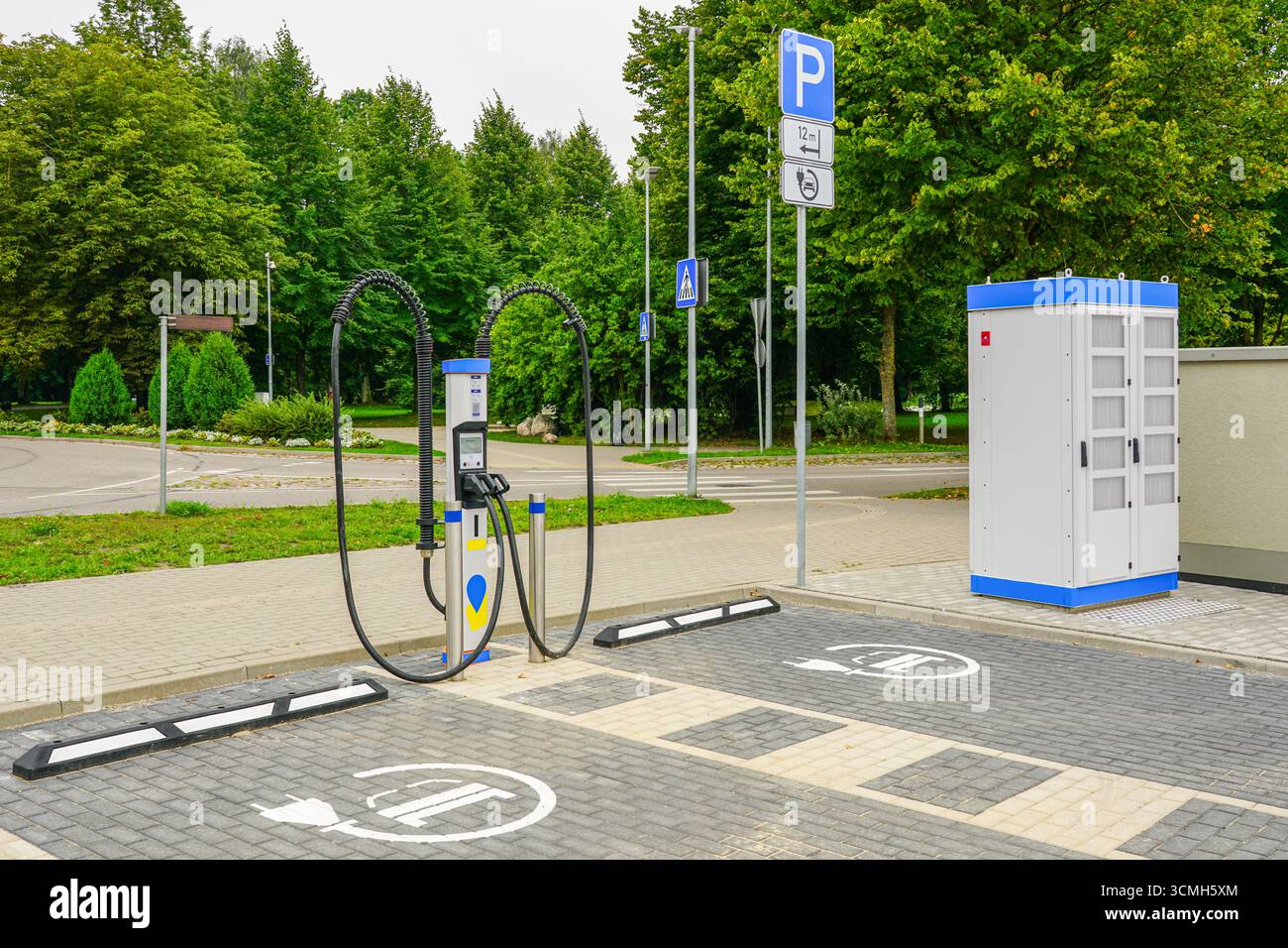 Moderna stazione di ricarica per veicoli elettrici con posti auto e armadietto elettrico, per una mobilità urbana pulita e sostenibile Foto Stock