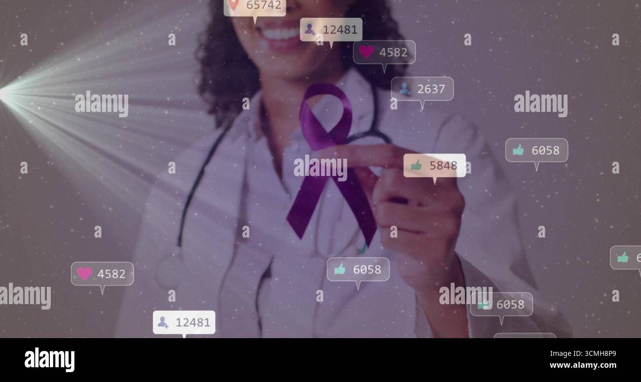 Medico sorridente che indossa un cappotto bianco e uno stetoscopio che punta al nastro viola in studio con le bolle Foto Stock