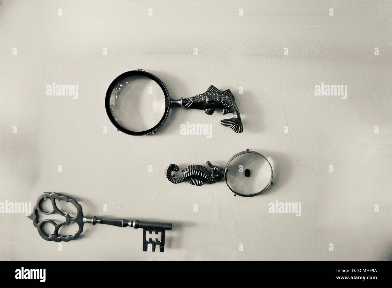 Set di lenti d'ingrandimento vintage e decorazioni a parete con chiavi antiche Foto Stock