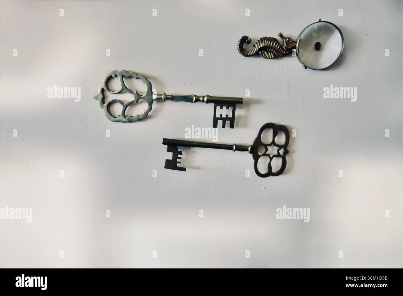 Set di lenti d'ingrandimento vintage e decorazioni a parete con chiavi antiche Foto Stock