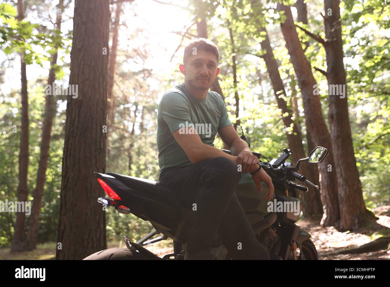 Bel giovane con una moderna moto all'aperto Foto Stock
