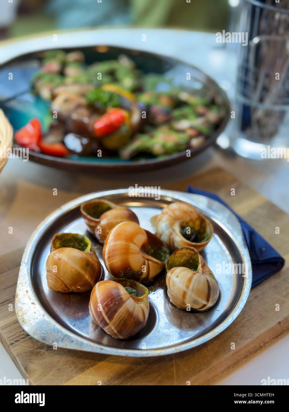 Lumache con salsa al pesto in un ristorante francese. Cucina nazionale francese Foto Stock