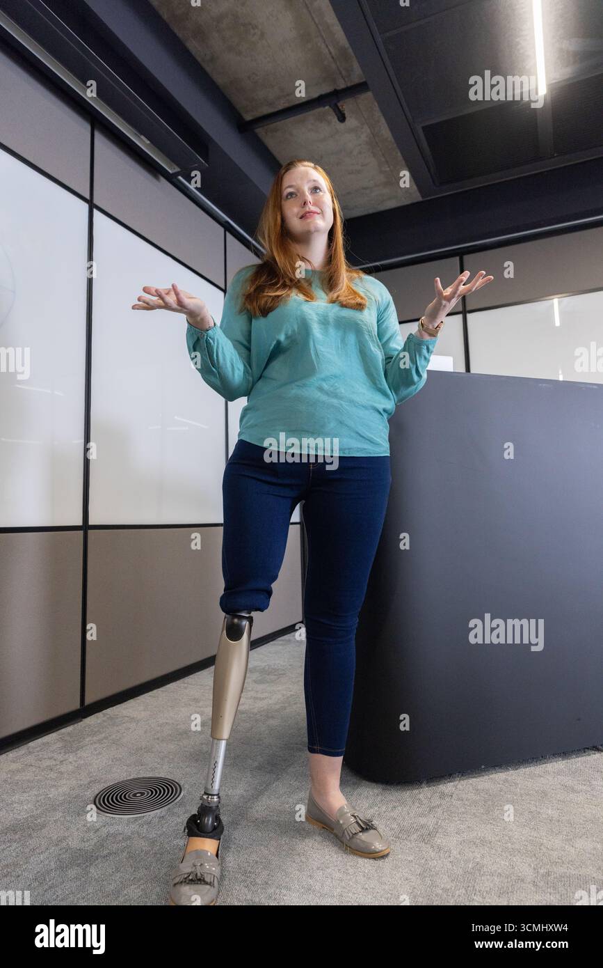 Banco ricevimento scuro in piedi in un moderno ufficio sotto travi a soffitto con illuminazione a LED Foto Stock