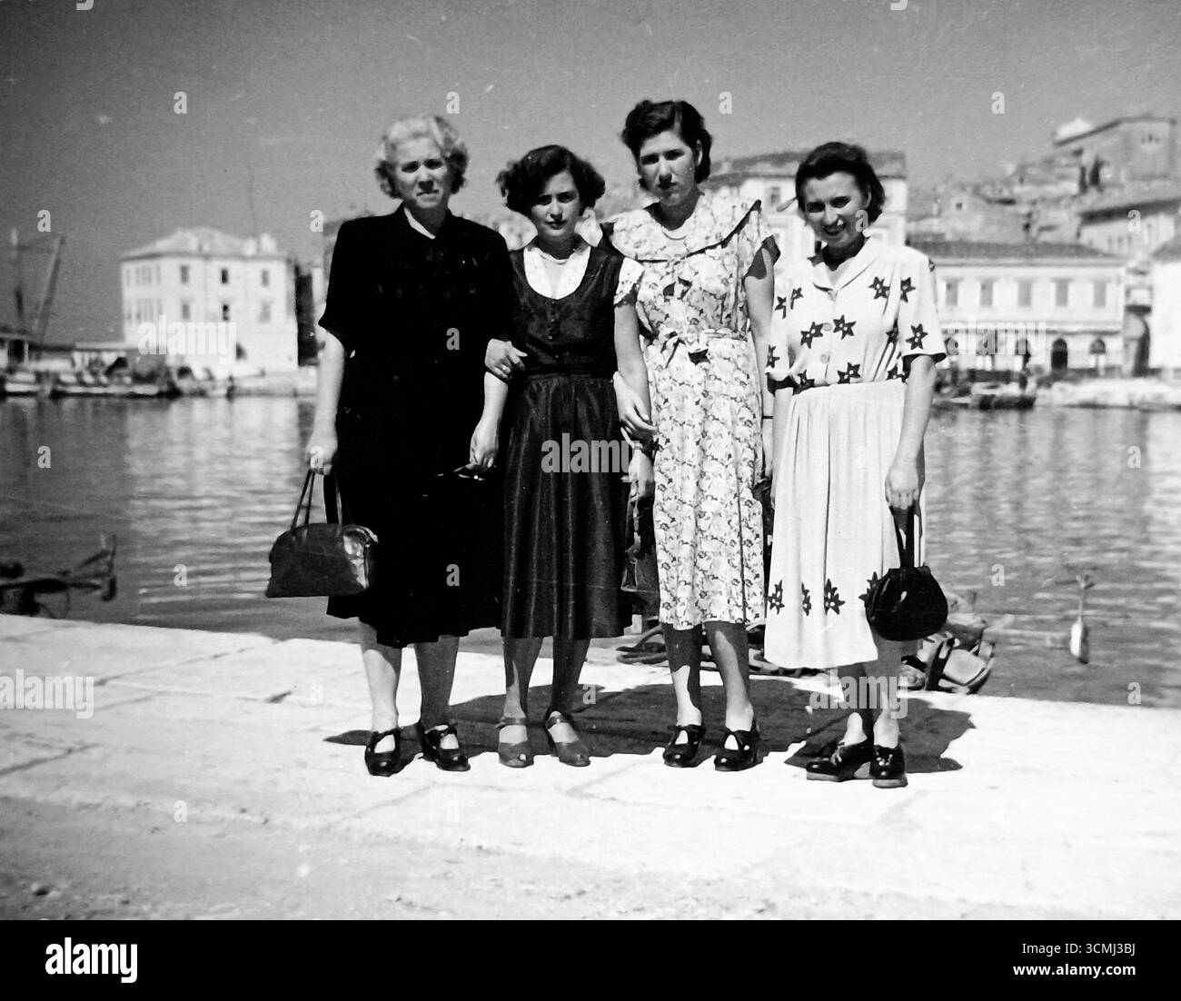 Rovigno, Croazia, Jugoslavia - anni '1940: Un ritratto di gruppo sul lungomare di Rovigno. In una soleggiata giornata estiva, eleganti negli abiti estivi, le donne posano per un souvenir della loro vacanza. Foto Stock