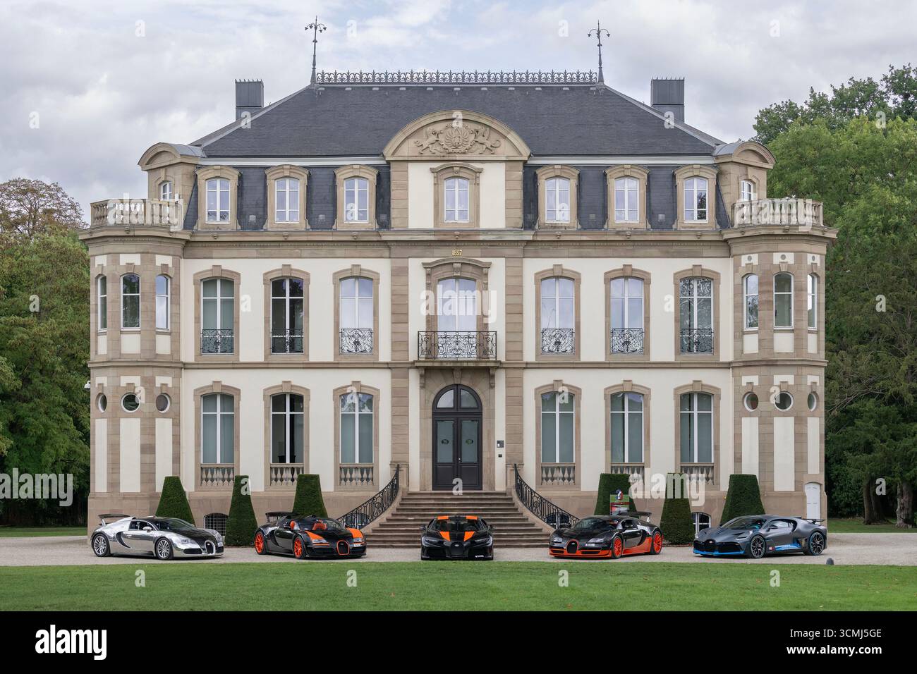 Dorlisheim, Francia - Castello di Saint-Jean che ospita la sede della Bugatti Automobiles con Bugatti Veyron, Chiron e Divo parcheggiati di fronte. Foto Stock