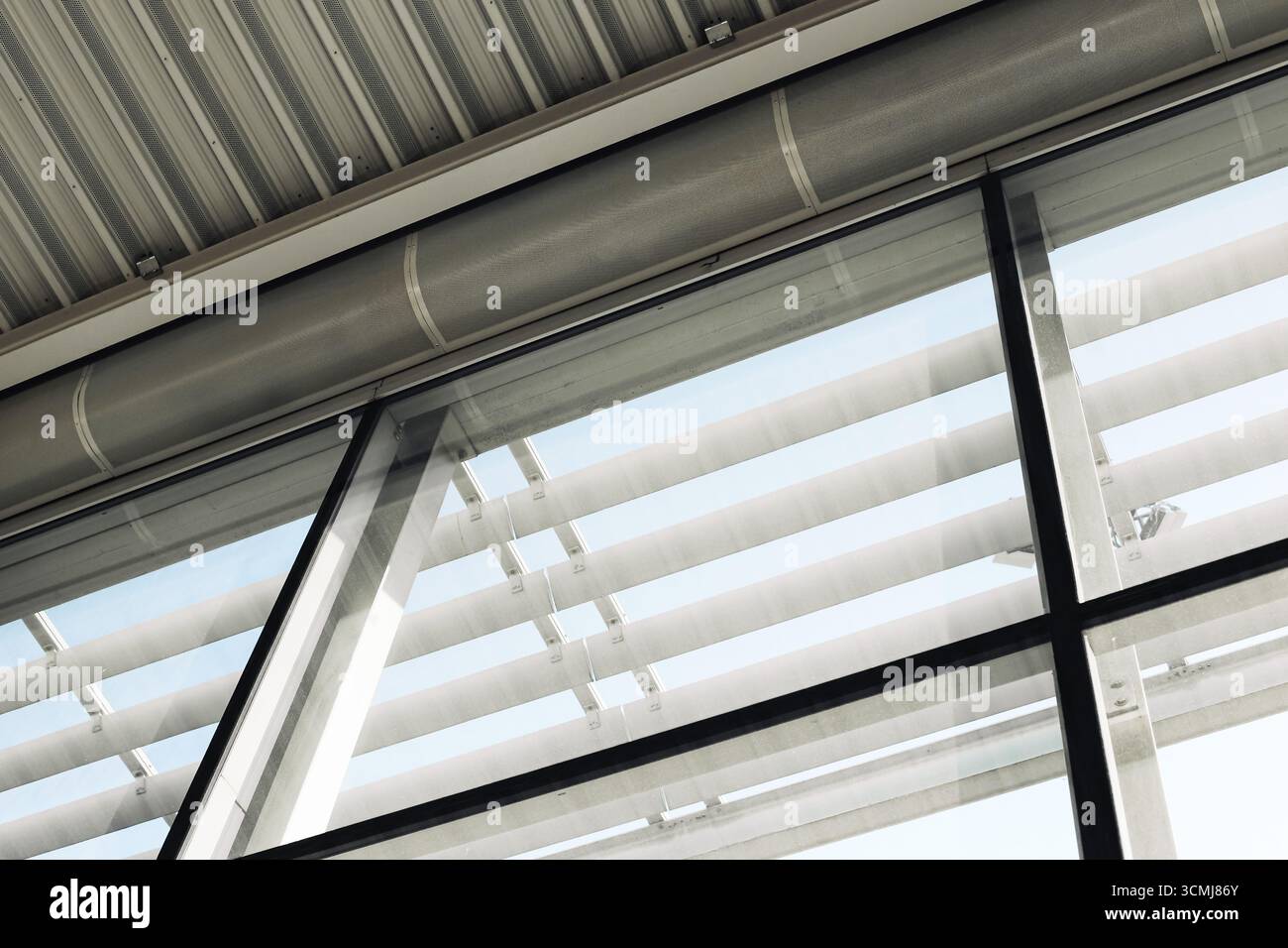 Edificio moderno con tetto. Dettagli dell'architettura industriale in vetro e acciaio. Linee geometriche dal design urbano. Interni strutturali. Foto Stock
