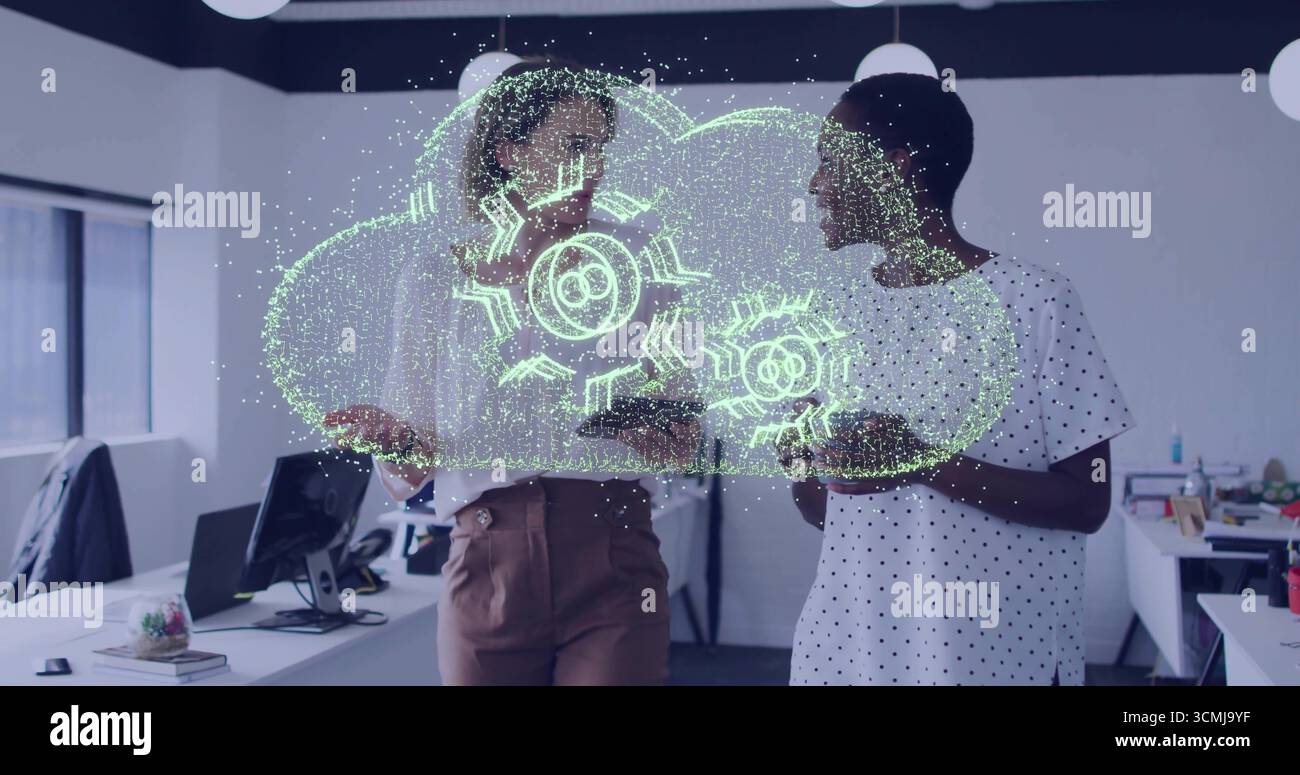 Revisione dell'ologramma del cloud con Gears, due colleghi che collaborano in un ufficio moderno, con i dispositivi Foto Stock