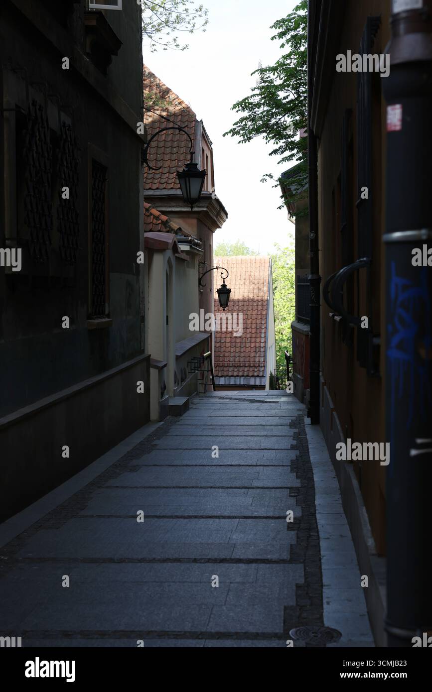 Vivace vicolo di Varsavia con ingresso storico e facciate color pastello illuminate dal sole, bellezza urbana estiva alla moda Foto Stock