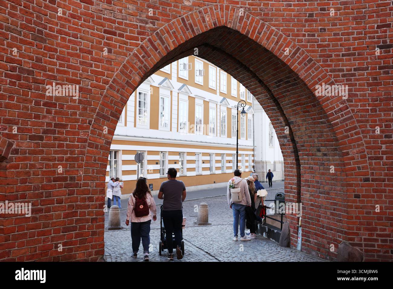 La città vecchia di Varsavia attraverso finestre in mattoni rossi, contrasto in primo piano e lussureggiante sfondo primaverile Foto Stock