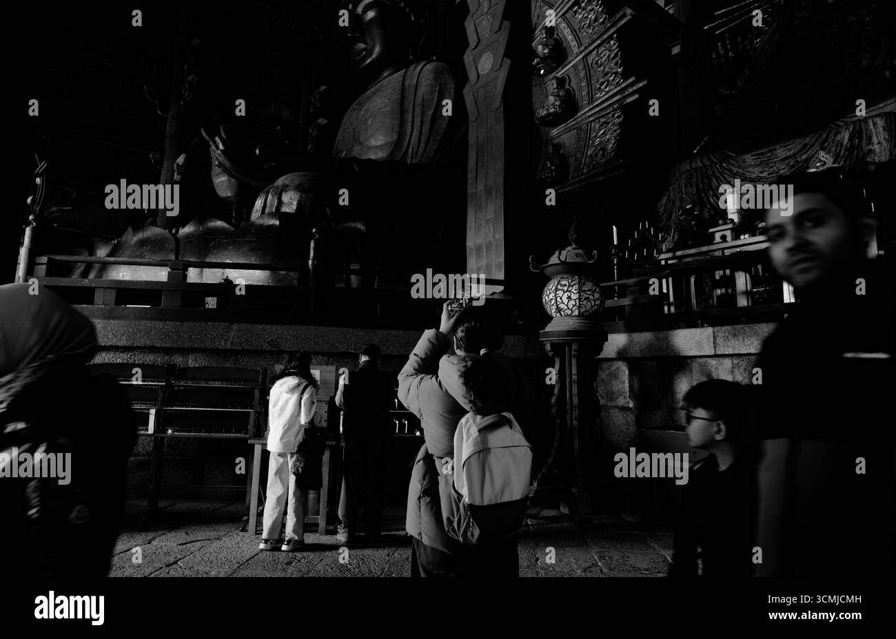 Il visitatore fotografa la grande statua del buddha all'interno del tempio Todai-ji a Nara Foto Stock
