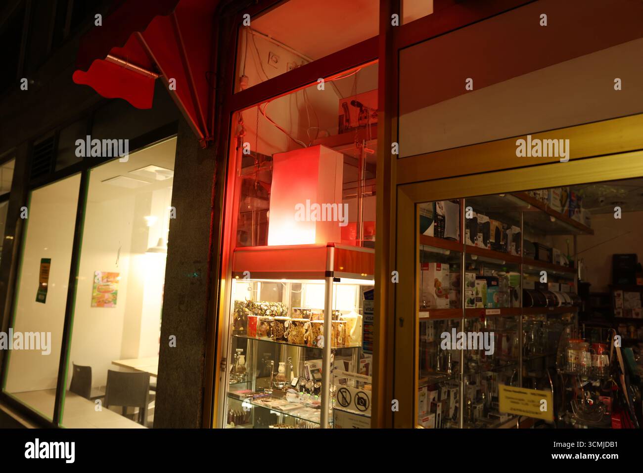 Il punto vendita di Varsavia di notte con tendalino rosso e vetrina curata Foto Stock