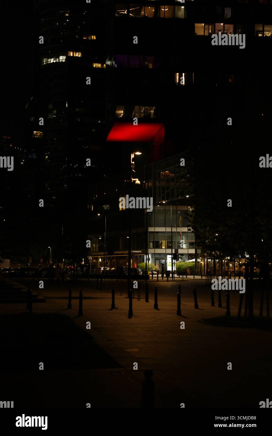 Una lanterna rossa si illumina nella piazza del parco di Varsavia, suggestiva scena notturna Foto Stock
